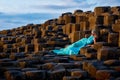 Beautiful blonde woman in turquoise long dress at Giants Causeway in North Ireland Royalty Free Stock Photo