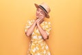 Beautiful blonde woman on vacation wearing summer hat and dress over yellow background sleeping tired dreaming and posing with Royalty Free Stock Photo