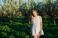 Beautiful blonde woman walking in blooming garden in spring Royalty Free Stock Photo