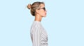 Beautiful blonde woman wearing business shirt and glasses looking to side, relax profile pose with natural face with confident Royalty Free Stock Photo