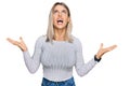 Beautiful blonde woman wearing casual clothes crazy and mad shouting and yelling with aggressive expression and arms raised Royalty Free Stock Photo