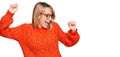 Beautiful blonde woman wearing casual clothes and glasses dancing happy and cheerful, smiling moving casual and confident Royalty Free Stock Photo