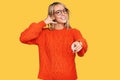 Beautiful blonde woman wearing casual clothes and glasses smiling doing talking on the telephone gesture and pointing to you Royalty Free Stock Photo