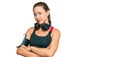 Beautiful blonde woman wearing gym clothes and using headphones looking to the side with arms crossed convinced and confident Royalty Free Stock Photo