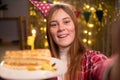 Beautiful blonde woman wearing shirt holding birthday cake and taking selfie photo celebrating at home