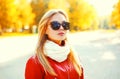 Beautiful blonde woman wearing a sunglasses and red jacket with scarf in autumn Royalty Free Stock Photo