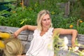 Beautiful blonde woman in white dress sitting outside in garden Royalty Free Stock Photo