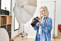 Beautiful blonde woman working as professional photographer at photography studio Royalty Free Stock Photo