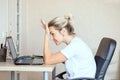 Beautiful blonde woman working on laptop at home. She is thoughtful and focused on work. Freelance, work at home concept. Royalty Free Stock Photo