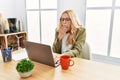 Beautiful blonde woman working at the office with laptop bored yawning tired covering mouth with hand Royalty Free Stock Photo