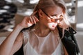 Beautiful blonde young bride woman in white wedding dress, black leather jacket and sunglasses. Royalty Free Stock Photo