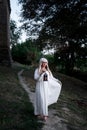 Blonde girl in a white dress on nature near architectural monuments in the open air