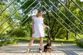 A beautiful blonde young woman with dog sitting next to her in the park Royalty Free Stock Photo