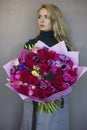 Beautiful blonde young woman holding in hands big bouquet Royalty Free Stock Photo