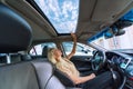 Blonde woman in modern car. Raindrops on a glass roof of the car Royalty Free Stock Photo