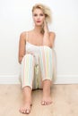Beautiful blonde young woman with pants sitting on the floor Royalty Free Stock Photo