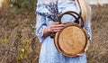 Beautiful blondie woman with trendy nude rattan round bag walking outdoors. Royalty Free Stock Photo