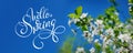 Beautiful blooming spring garden on a background of blue sky and text Hello Spring. Calligraphy lettering