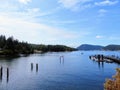 A beautiful blue bay with wooden jetties and a dock with boats surrounded by forested islands on Mayne Island, British Columbia