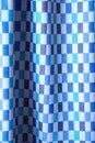 Beautiful blue checkered fabric texture with folds and contrasting shadows. Draped background of cotton, texture Royalty Free Stock Photo