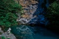 beautiful blue clear emerald lake, glowing in the sun, pond near rocky cliff crag and trees