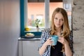 Beautiful blue-eyed blond woman drinking coffe or tea from the cup. Royalty Free Stock Photo