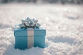 A beautiful blue gift box with a bow placed on it, resting in the midst of pure white snow, A blue gift box wrapped in silver bows Royalty Free Stock Photo