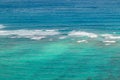 Beautiful blue green turquoise teal shallow tropical water with waves breaking on a coral reef on Oahu, Hawaii, USA