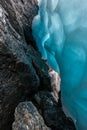 Beautiful blue ice next to water flowing over large stones.