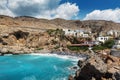 Beautiful blue lagoon with umbrellas at sandy beach, Chora Sfakion town, Crete island Royalty Free Stock Photo