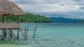 Beautiful Blue Lagoone with some Bamboo Huts, Kordiris Homestay, Palmtree in Front, Gam Island, West Papuan, Raja Ampat