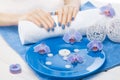 Beautiful blue manicure with orchid and towel on the white wooden table. spa Royalty Free Stock Photo