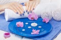 Beautiful blue manicure with orchid and towel on the white wooden table. spa Royalty Free Stock Photo