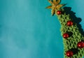 Beautiful blue minimalistic Christmas background. Handmade knitted Christmas tree with a gold tinsel star on the top of the head Royalty Free Stock Photo