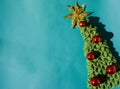 Beautiful blue minimalistic Christmas background. Handmade knitted Christmas tree with a gold tinsel star on the top of the head Royalty Free Stock Photo