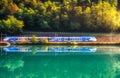 Beautiful blue modern high speed train and river in mountains Royalty Free Stock Photo