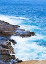 Beautiful blue ocean water hitting against rocky edge