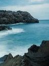 a beautiful blue ocean and waves crashing in on the rocks