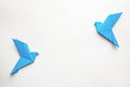 Beautiful blue origami birds on white background, flat lay. Space for text Royalty Free Stock Photo