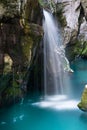 Beautiful blue river of Soca, Slovenia, with a blurred small waterfall