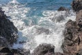 Beautiful blue sea and a beach with huge stone blocks. Danger sea wave crashing on rock coast with spray and foam. Stony coast Royalty Free Stock Photo