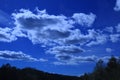 Blue skies with clouds over mountains.