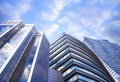 Beautiful blue sky with clouds reflecting in windows. Low angle view of modern buildings Royalty Free Stock Photo