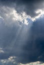 Beautiful vertical cloudscape with sun rays shining through the dark clouds Royalty Free Stock Photo