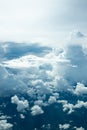 Beautiful blue sky with fluffy white clouds view through airplane window peaceful view above the island in the holiday morning Royalty Free Stock Photo