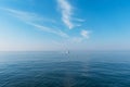 Beautiful blue sky with light white clouds. Boat cruising the sea leaving wake on a brilliant sunny day. Royalty Free Stock Photo