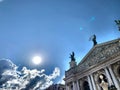 Beautiful blue sky with sun in the background opera building with sculptures on the roof