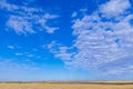 Beautiful blue sky with white clouds over wheat fields during harvest Royalty Free Stock Photo