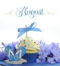 Beautiful blue Summer holiday theme cupcake with seasonal flowers and decorations for the month of August Royalty Free Stock Photo