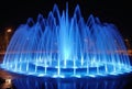 beautiful blue water fountain with LED lights at night generative AI Royalty Free Stock Photo